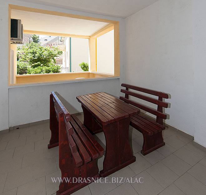 veranda with wooden table and chairs, bench